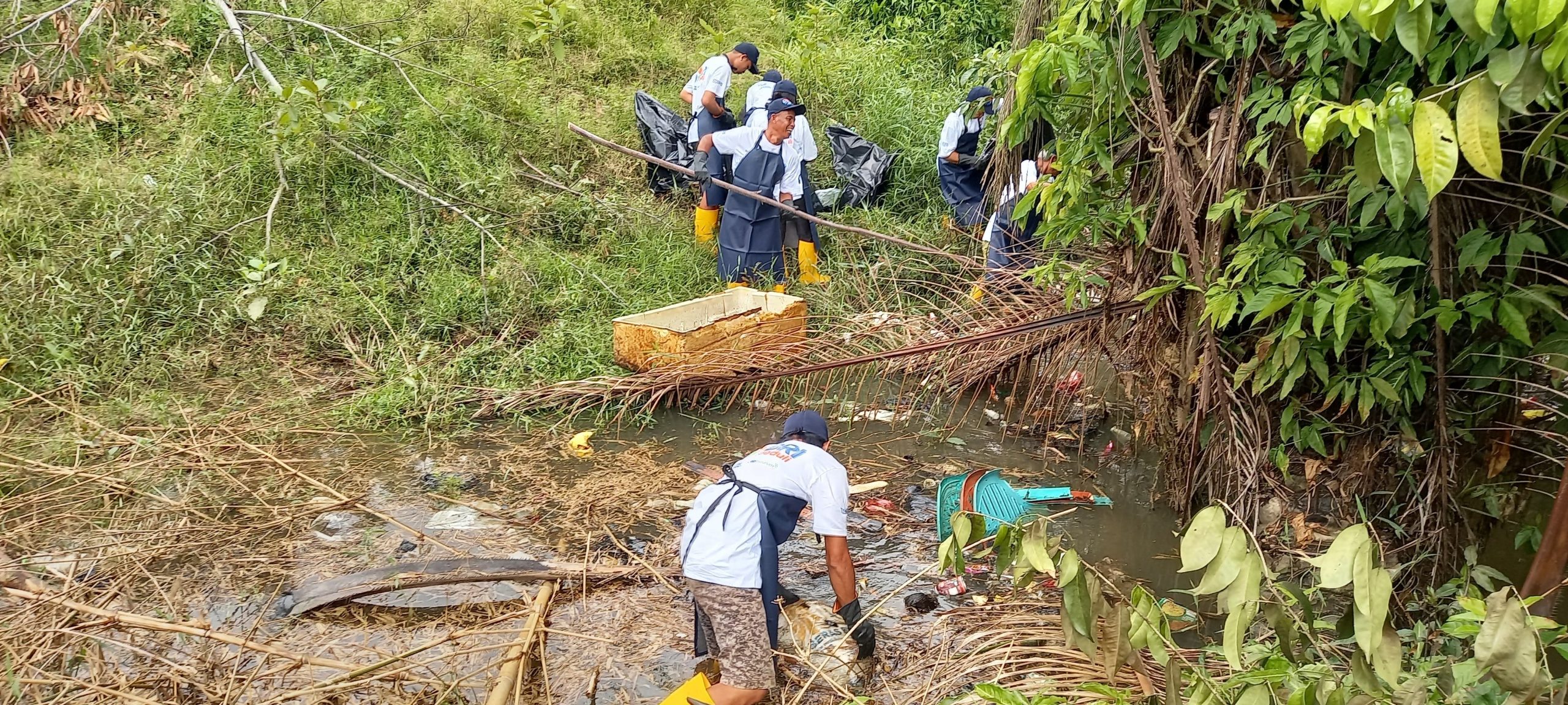 Pihak BRI bersama warga ketika melakukan pembersihan sampah sekitar sungai. (Dedi Irawan)